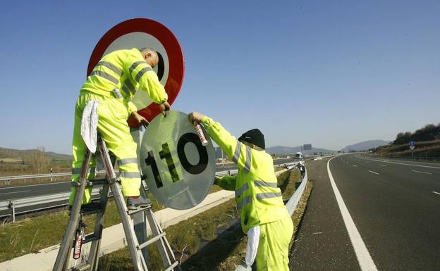 Operarios trabajan en la renovación de señales de tráfico. 