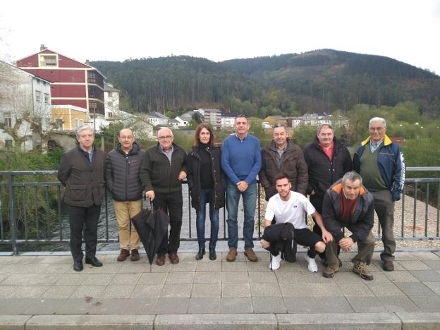 Los pescadores, con el director Manuel Calvo (de azul), en el puente sobre el río Esva en Trevías. 