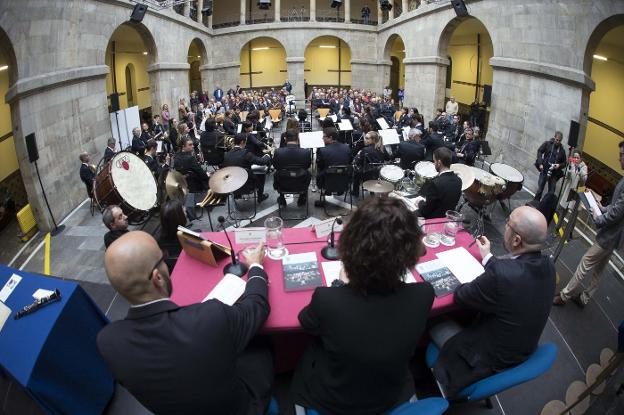 Miguel Ángel Martín Piris, presidente de la Banda; la concejala Montserrat López, y Javier Granda Álvarez, autor del libro, frente a la Banda de Música de Gijón. 