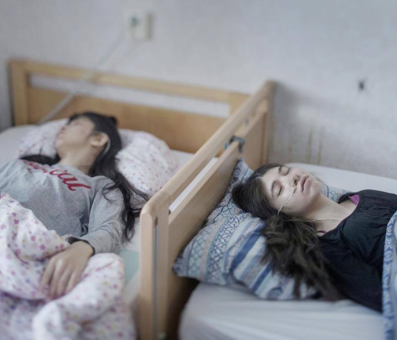 La foto muestra a Djeneta (d) postrada en cama y sin responder durante dos años y medio, y a su hermana Ibadeta, en la misma situación durante más de seis meses, gracias al uppgivenhetssyndrom (síndrome de resignación), en Horndal, Suecia, el 2 de marzo de 2017.