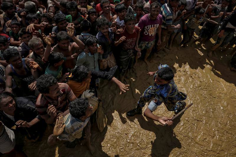 Un oficial de seguridad intenta controlar a los refugiados rohinyás que esperan recibir ayuda en Cox's Bazar (Bangladés), el 21 de septiembre de 2017.