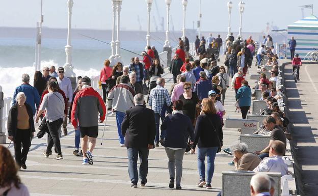 Imagen. Numerosos gijoneses aprovecharon el buen tiempo para dar un paseo por el Muro.