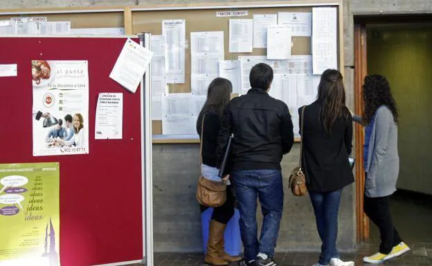 Un grupo de alumnos consulta unas notas en el tablón de una facultad de la Universidad de Oviedo.