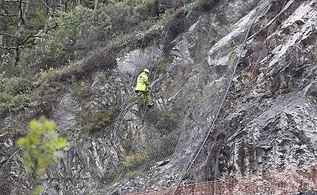 Un operario coloca la malla metálica en Anzó.