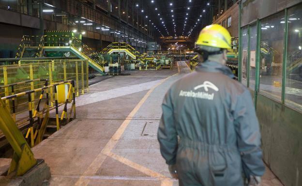 Un operario se dirige a una de las cabinas de control de uno de los trenes de la factoría gijonesa de Arcelor. 