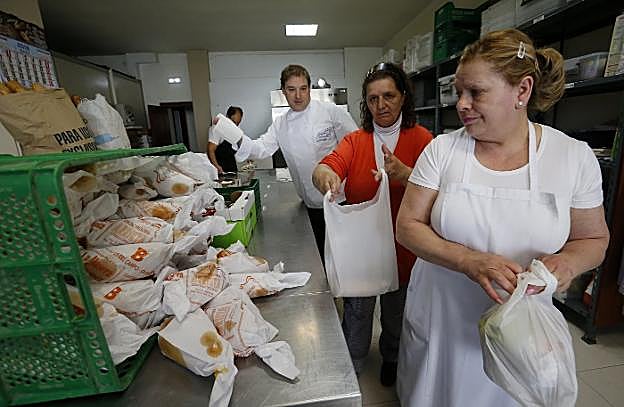 Voluntarios de la Cocina Económica con los bollos. :: PABLO LORENZANA