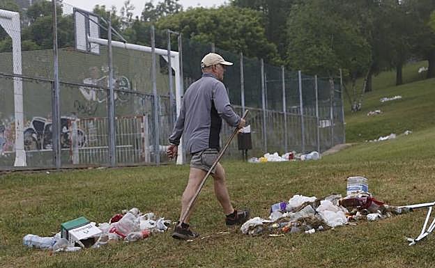 Un hombre camina entre restos de basura.