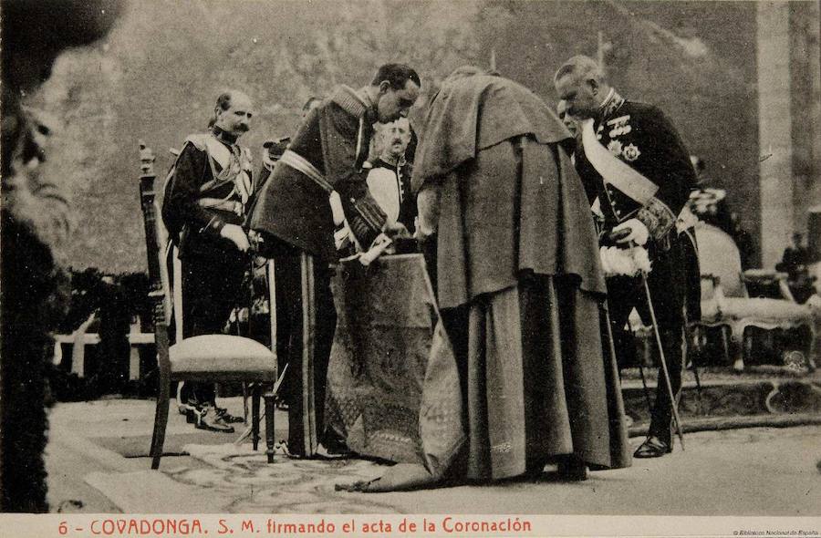 S.M. firmando el acta de la Coronación.