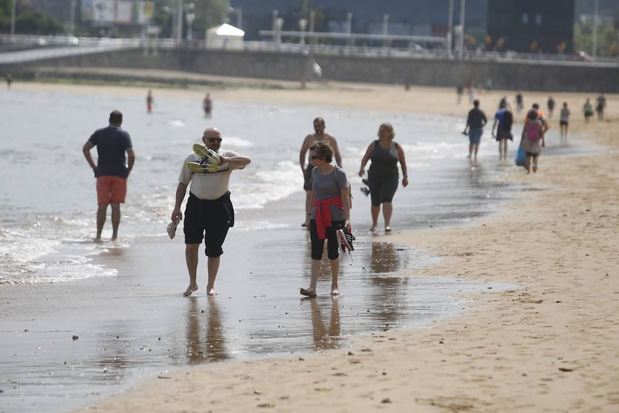 Tras dos días cerrada por vertidos, el Ayuntamiento de Gijón ha izado la bandera verde en la playa de San Lorenzo en un día de tiempo agradable que ha animado a numerosos vecinos y visitantes a acercarse al arenal.