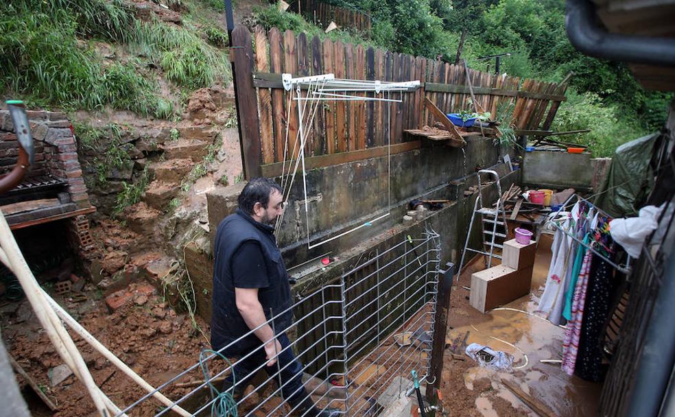 El propietario de la casa que tuvo que ser desalojada por el argayo examina los desperfectos causados por la riada de lodo.