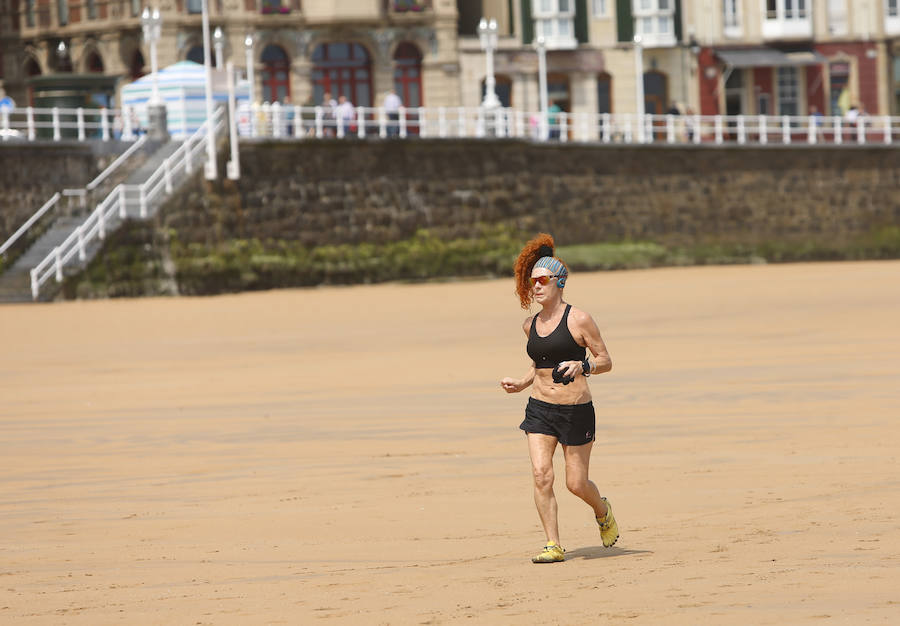Las banderas amarilla y verde que luce la playa y la buena temperatura ya ha animado a algunas personas a pegarse un baño en el Cantábrico. 
