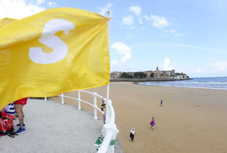 Las banderas amarilla y verde que luce la playa y la buena temperatura ya ha animado a algunas personas a pegarse un baño en el Cantábrico. 
