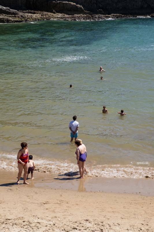 Miles de personas disfrutan del primer fin de semana del verano en las playas de Asturias. Arenales como San Lorenzo, en Gijón, o Rodiles, en Villaviciosa, están a rebosar. 