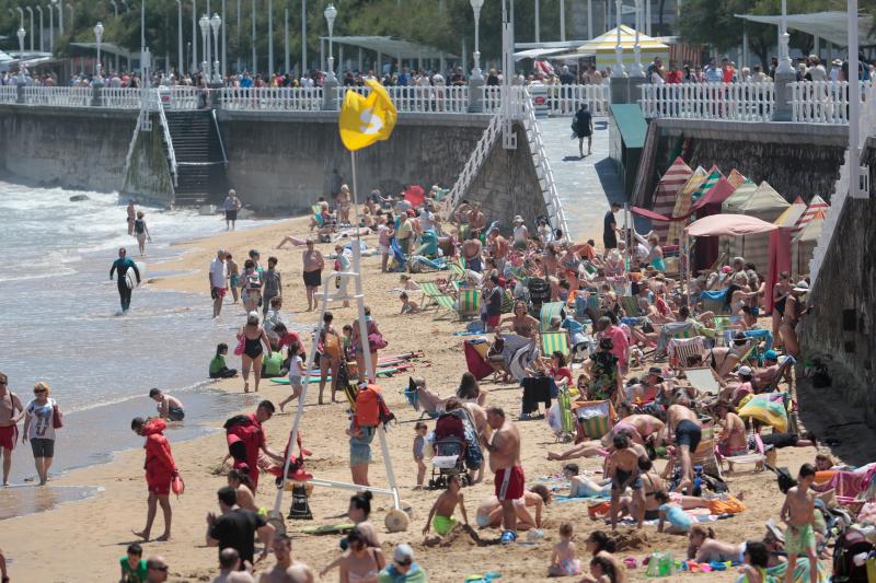 Miles de personas disfrutan del primer fin de semana del verano en las playas de Asturias. Arenales como San Lorenzo, en Gijón, o Rodiles, en Villaviciosa, están a rebosar. 