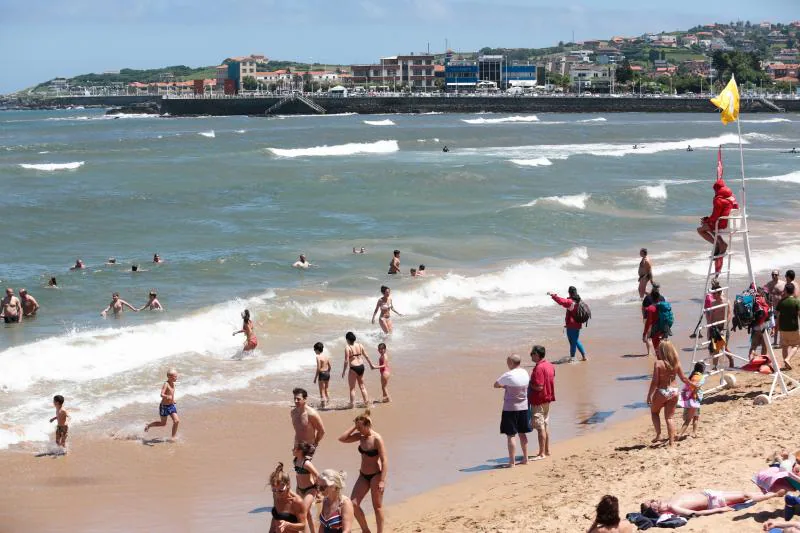 Miles de personas disfrutan del primer fin de semana del verano en las playas de Asturias. Arenales como San Lorenzo, en Gijón, o Rodiles, en Villaviciosa, están a rebosar. 