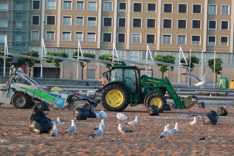 La fiesta de San Juan ha dejado toneladas de basura en la playa de Poniente. Desde antes del amanecer, operarios de Emulsa trabajan en la recogida de los residuos para dejar listo el arenal para un nuevo día de pleno verano.