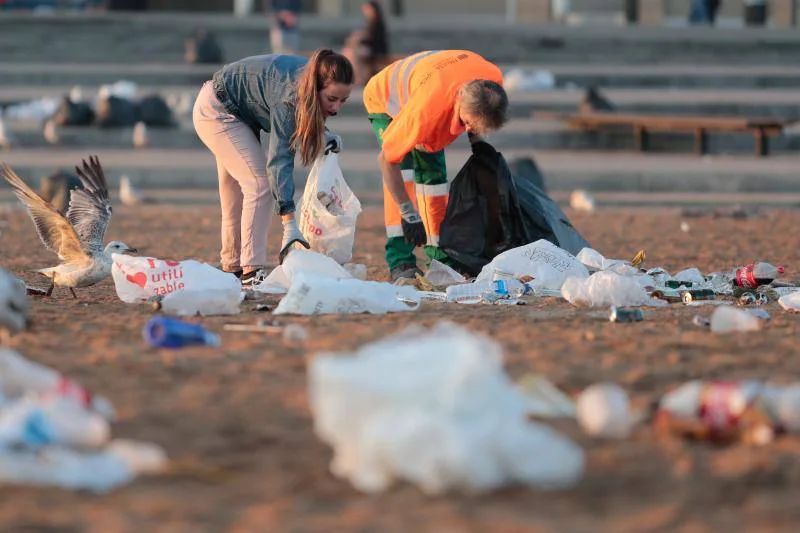 La fiesta de San Juan ha dejado toneladas de basura en la playa de Poniente. Desde antes del amanecer, operarios de Emulsa trabajan en la recogida de los residuos para dejar listo el arenal para un nuevo día de pleno verano.