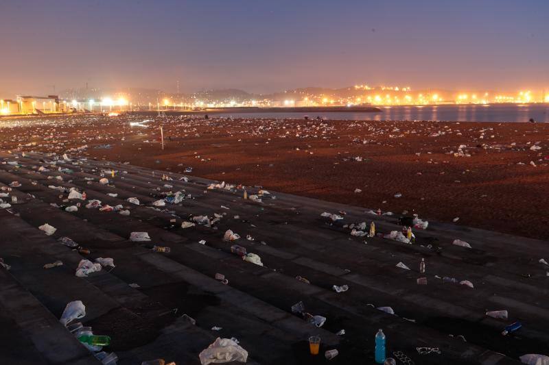 La fiesta de San Juan ha dejado toneladas de basura en la playa de Poniente. Desde antes del amanecer, operarios de Emulsa trabajan en la recogida de los residuos para dejar listo el arenal para un nuevo día de pleno verano.