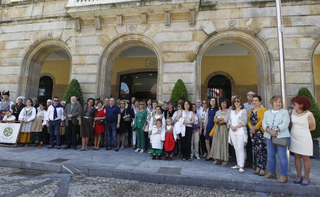 Los profesores jubilados frente al Ayuntamiento, junto a concejales y el grupo folclórico Trebeyu.. 