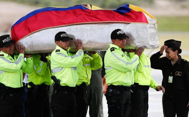 Miembros de la Policía Nacional trasladan los restos mortales de la pareja ecuatoriana secuestrada en abril a su llegada al aeropuerto de Tababela, en Quito (Ecuador).