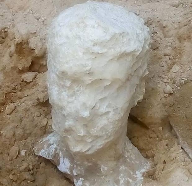 Foto cedida por el Ministerio Egipcio de Antigüedades que muestra una cabeza esculpida en alabastro hallada junto a un sarcófago de granito negro en un sitio arqueológico en Alejandría.