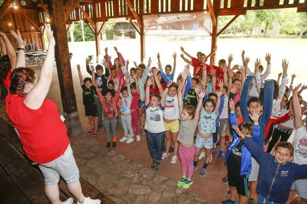 Los niños del campamento del Museo del Pueblo de Asturias esperan a que sus monitores les expliquen el juego que van a realizar. 