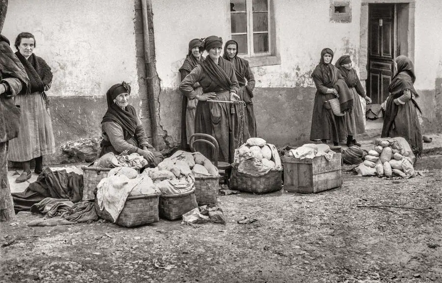 Mujeres venden mantequilla envuelta en hojas de repollo en Tineo.