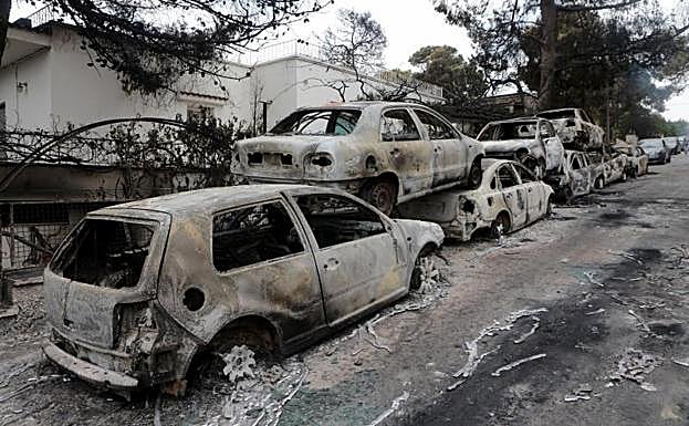 Varios coches calcinados en una zona afectada por los incendios en Argyra Akti, en Mati.