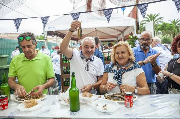 Un grupo de asistentes disfruta de sus platos de sardinas y una botella de sidra en una de las barras de los establecimientos participantes, que no dejaron de servir durante toda la tarde. 