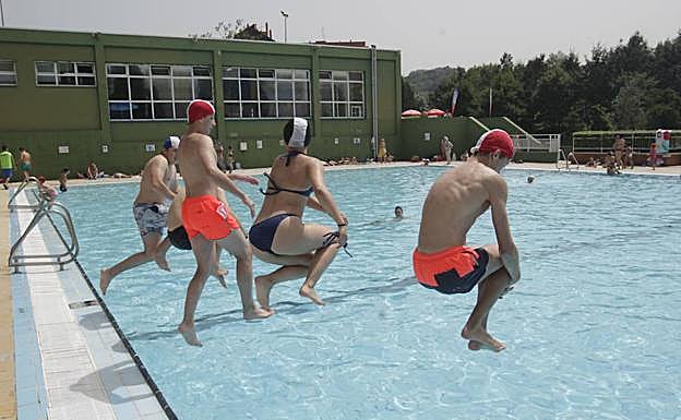 Imagen. Oviedo. Varios jóvenes se zambullen en la piscina. 