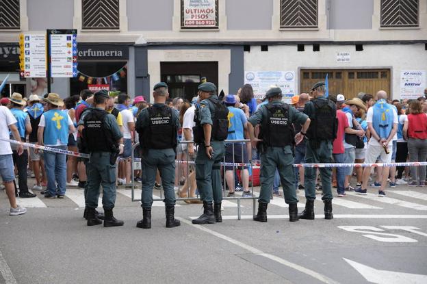 Efectivos de la Unidad de Seguridad Ciudadana controlan una de las bocacalles de la vía principal de Arriondas durante el desfile. 