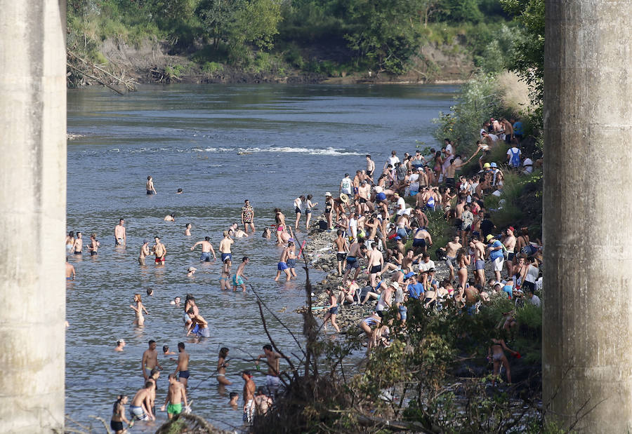 Miles de personas disfrutan de la popular fiesta del Xiringüelu en el prau Salcéu de Pravia en una jornada marcada por el sol y el intenso calor. 