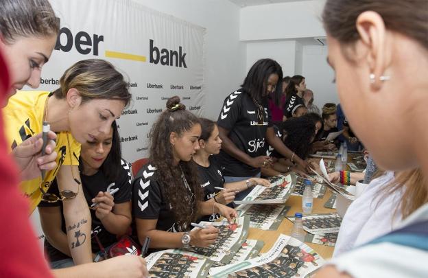 Las jugadoras del Liberbank firman autógrafos a los aficionados que se acercaron ayer a la presentación del equipo en la Feria. 