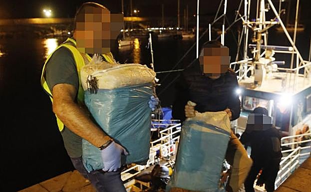 Guardias civiles descargan en Cudillero los dos fardos localizados por el 'Cruz del Sur'. 