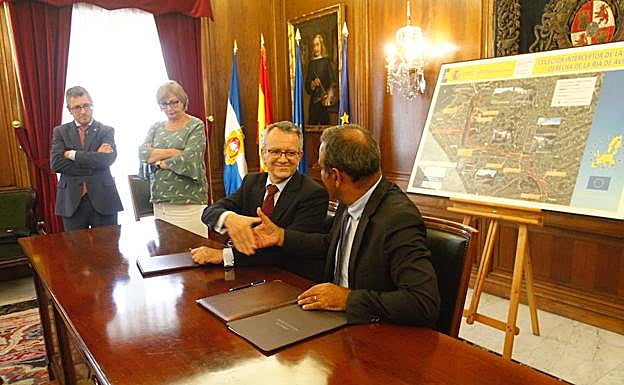 Manuel Gutiérrez y Fernando Lastra se saludan después de la firma de la cesión. A su derecha, Hugo Morán y Mariví Monteserín. 