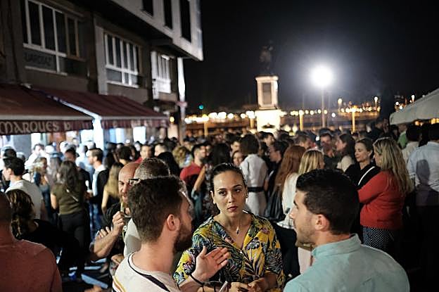 Ambiente, de madrugada, en la plaza del Marqués. A la izquierda, basura en la playa de Poniente tras los fuegos. 