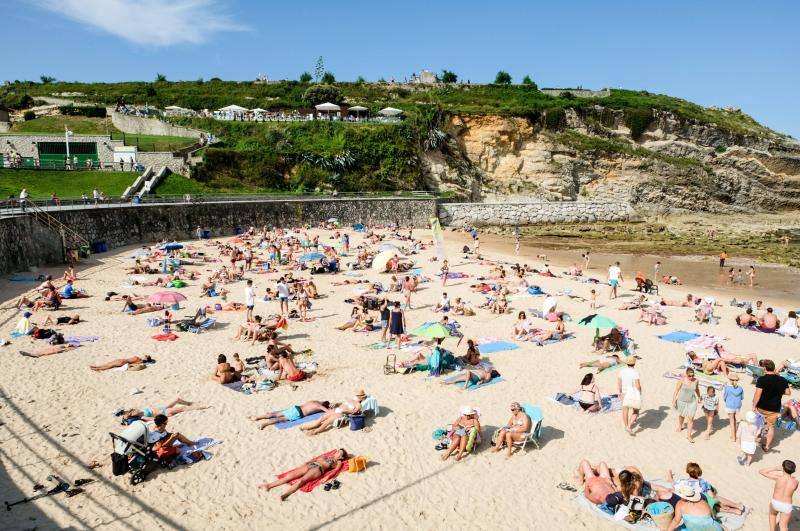 El sol y el calor anunciados para este fin desemana han llenado las playas de Asturias. En San Lorenzo, por ejemplo, miles de personas disfrutan del arenal y del paseo del Muro.