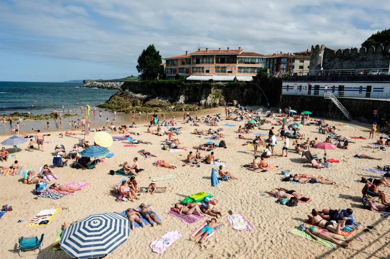 El sol y el calor anunciados para este fin desemana han llenado las playas de Asturias. En San Lorenzo, por ejemplo, miles de personas disfrutan del arenal y del paseo del Muro.