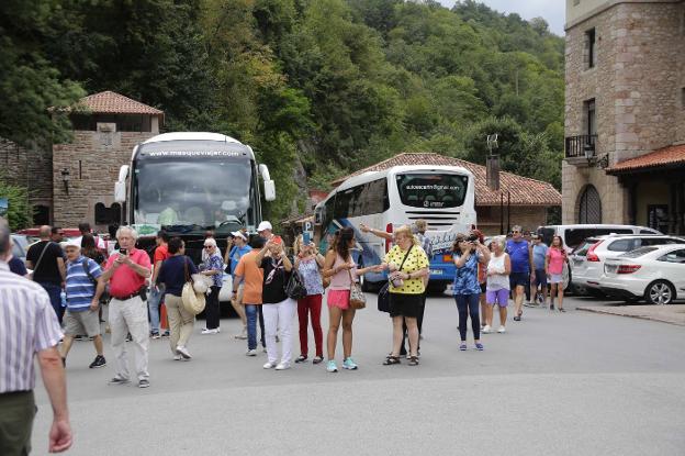 Decenas de turistas, recién llegados a Covadonga en autobús. 