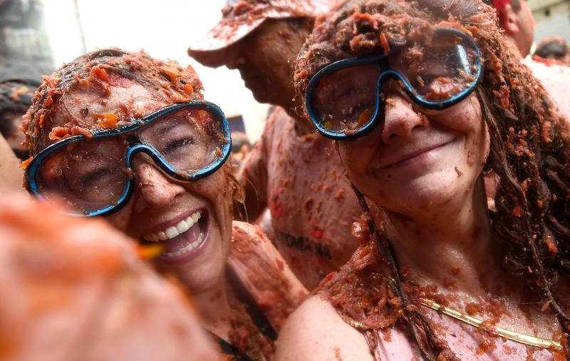 La localidad valenciana de Buñol se ha teñido de fiesta en la popular Tomatina, que ha congregado a unas 20.000 personas han lanzado unos 145.000 kilos de tomate repartidos en siete camiones, cifras que confirman que es una de las grandes citas festivas del verano en España. 