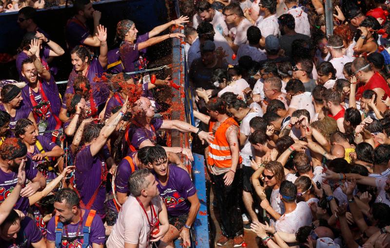 La localidad valenciana de Buñol se ha teñido de fiesta en la popular Tomatina, que ha congregado a unas 20.000 personas han lanzado unos 145.000 kilos de tomate repartidos en siete camiones, cifras que confirman que es una de las grandes citas festivas del verano en España. 