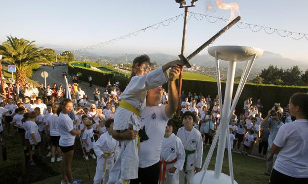 María Fear, la benjamina de la sección de kárate, enciende el pebetero de las Miniolimpiadas del Deporte.
