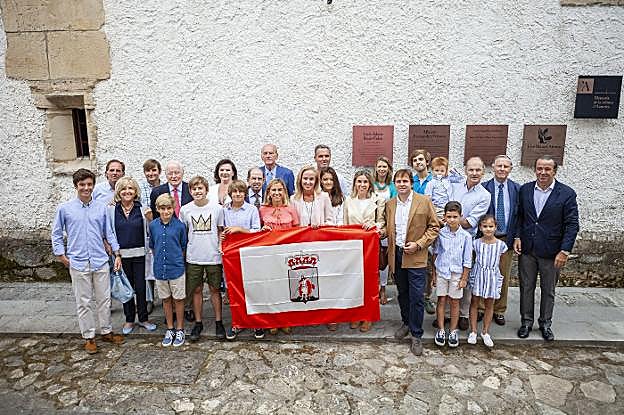 Tres generaciones de la familia Adaro posan con la bandera de Gijón junto a la placa descubierta ayer, en la Casa de los González de la Vega, en recuerdo a Luis Adaro Ruiz-Falcó, promotor de la idea de fundar el Pueblo de Asturias. 