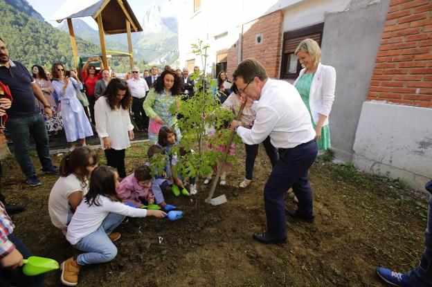 Los alumnos del aula de San Juan de Beleño del CRA Picos de Europa ayudan a Genaro Alonso a plantar un roble en el patio del colegio ante la atenta mirada de sus profesoras, Vanesa Vázquez Coello y Vanesa Uría, y la alcaldesa de Ponga, Marta Alonso (derecha). 