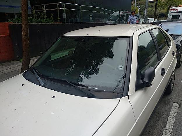 Impactos de la bala en la luna y en el techo del turismo, justo encima del espejo retrovisor. 