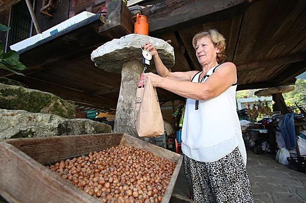 Isolina Lobeto pesa su cosecha de avellanas, que este año alcanza los cien kilos. 