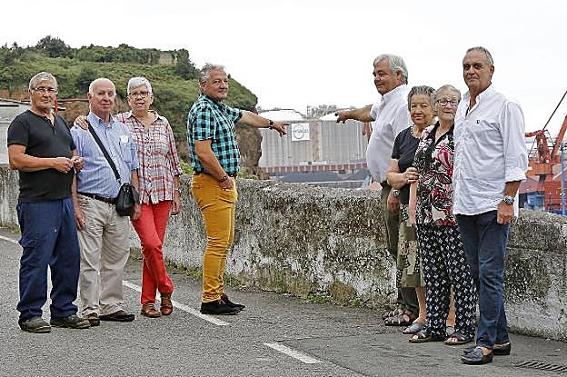 Varios vecinos de El Muselín, con la regasificadora de fondo. 