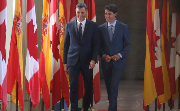 Pedro Sánchez (i) camina junto a Trudeau. 