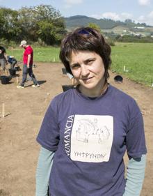 Imagen secundaria 2 - Arriba, el equipo de una decena de arqueólogos y voluntarios dirigido por Esperanza Martín posa en el yacimiento. A la izquierda, Laura Pavón retira una capa de tierra del yacimiento. A la derecha, Esperanza Martín, directora de los trabajos.