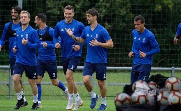 Imagen. Los jugadores azules realizan una carrera de calentamiento.